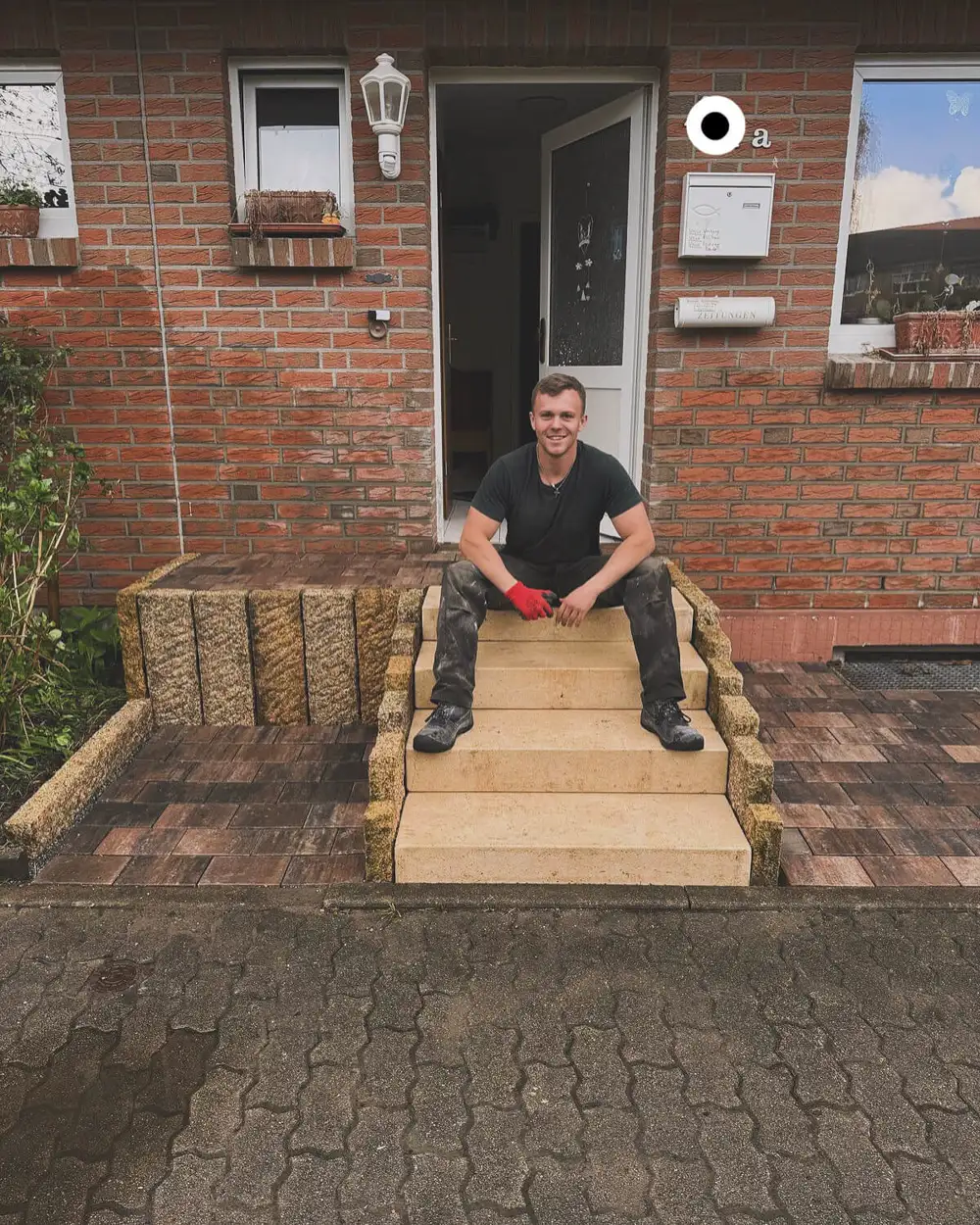 Leonard-Deon Moissé sitzt auf einer selbst gebauten Natursteintreppe aus seinem früheren Garten- und Landschaftsbau-Betrieb